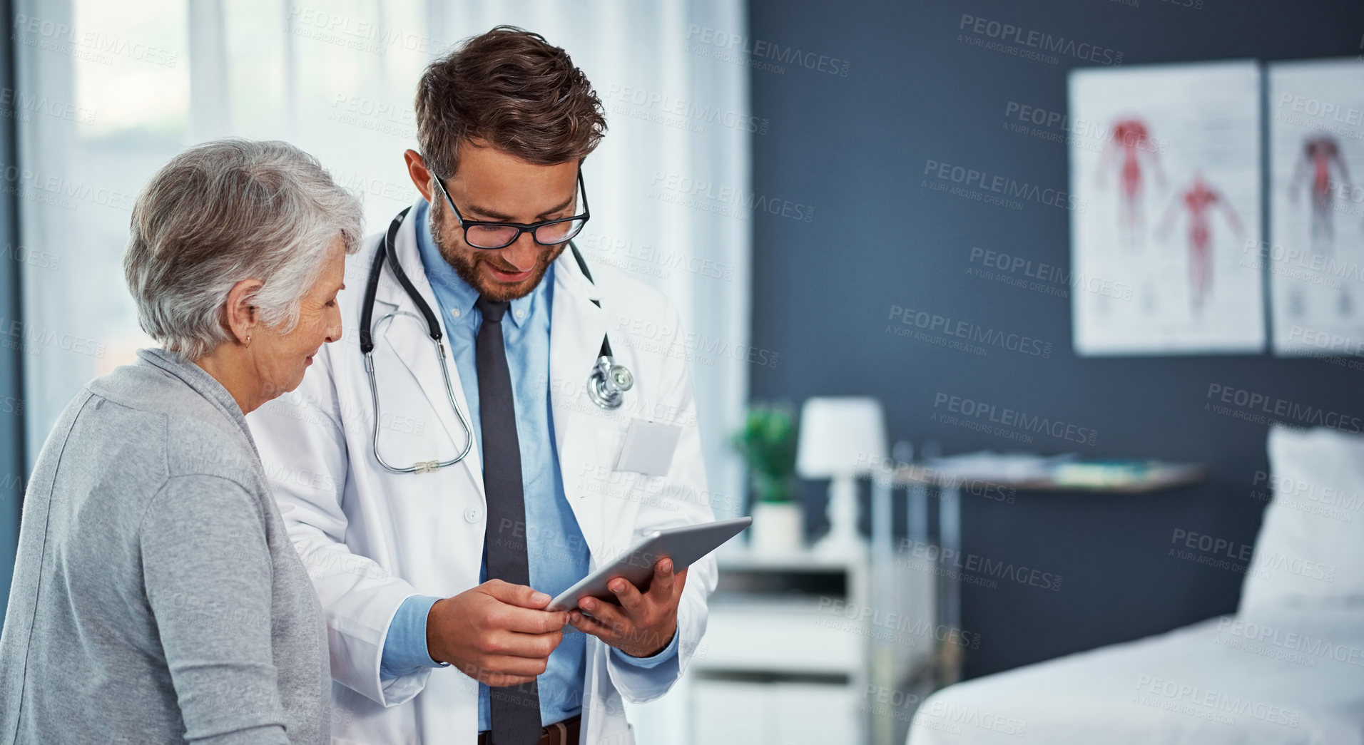 Buy stock photo Shot of a doctor discussing something on a digital tablet with a senior patient in a clinic