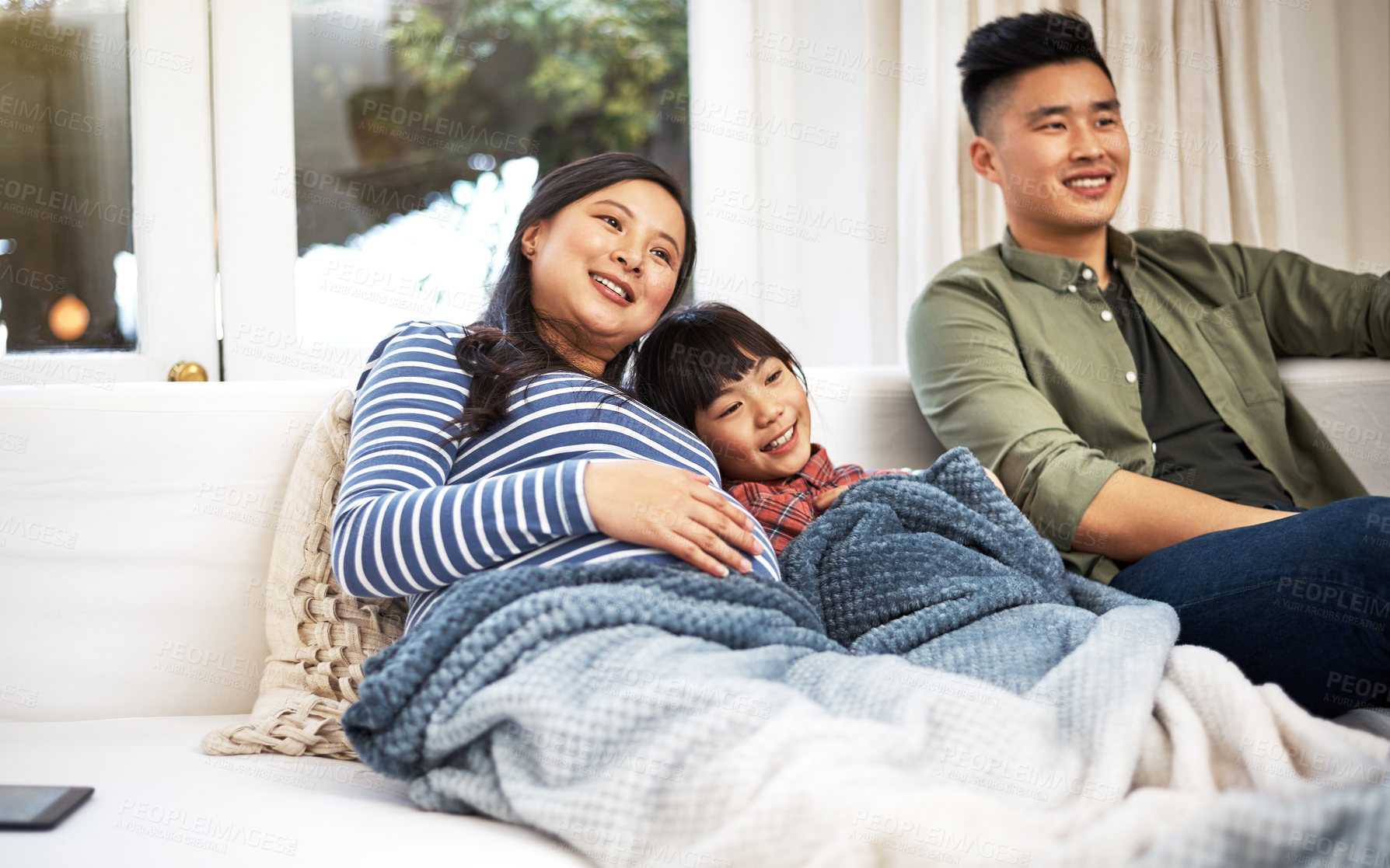Buy stock photo Relax, sofa and family in house watching tv with movie, film or show with bonding together. Happy, weekend and Asian kid with father and pregnant mother for streaming series in living room at home.
