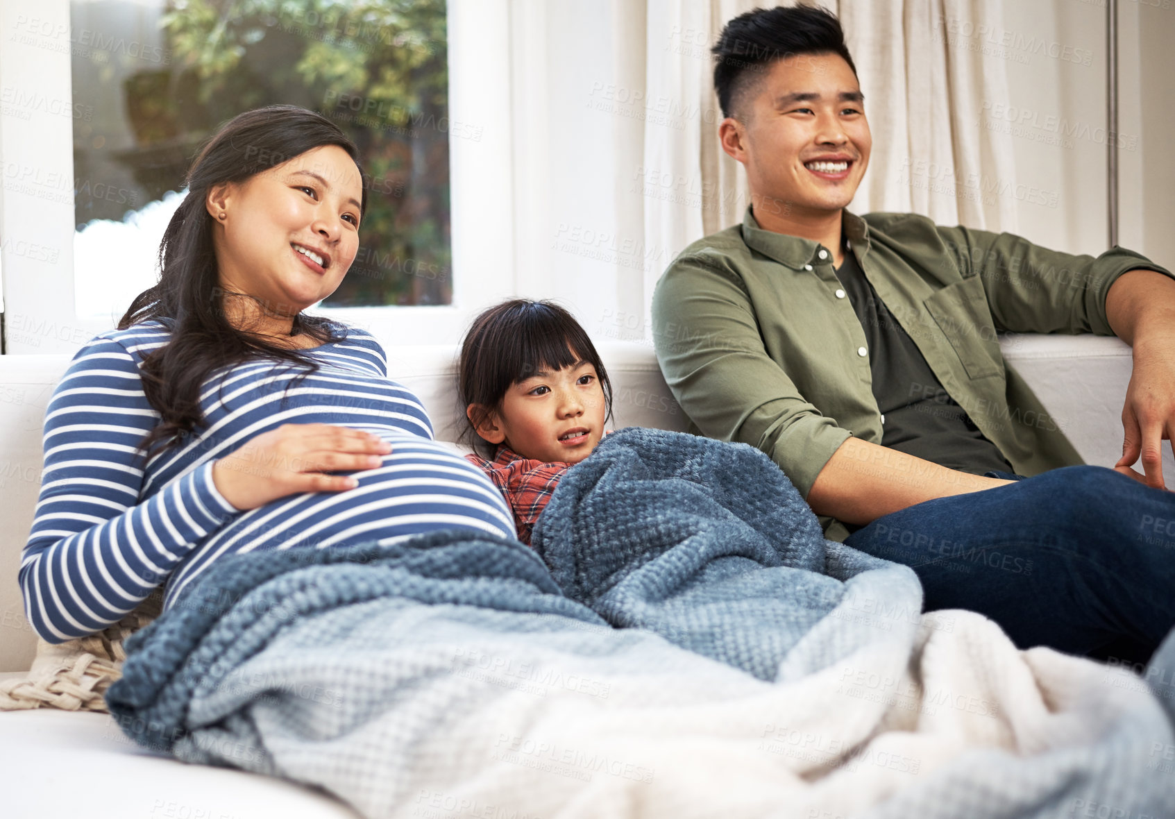 Buy stock photo Shot of a family watching television together at home