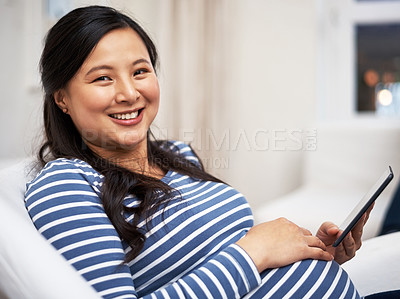Buy stock photo Portrait of a pregnant woman using a digital tablet at home