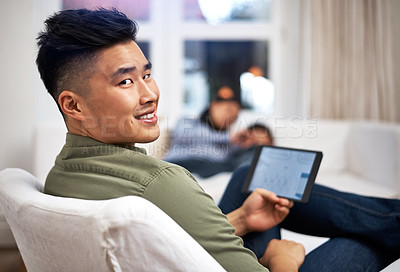 Buy stock photo Portrait of a man using a digital tablet with his family in the background