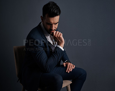 Buy stock photo Studio shot of a stylish young businessman looking thoughtful against a gray background