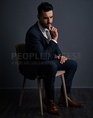 Buy stock photo Studio shot of a stylish young businessman looking thoughtful against a gray background