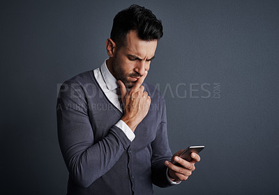 Buy stock photo Doubt, planning and businessman in studio with phone for networking, texting or email with legal case. Technology, unsure and male lawyer with cellphone for online feedback by gray background.
