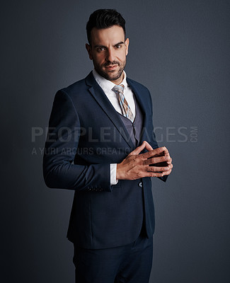 Buy stock photo Studio shot of a stylish and confident young businessman posing against a gray background