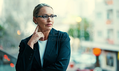 Buy stock photo Shot of a mature businesswoman standing outside on the balcony of her corporate office
