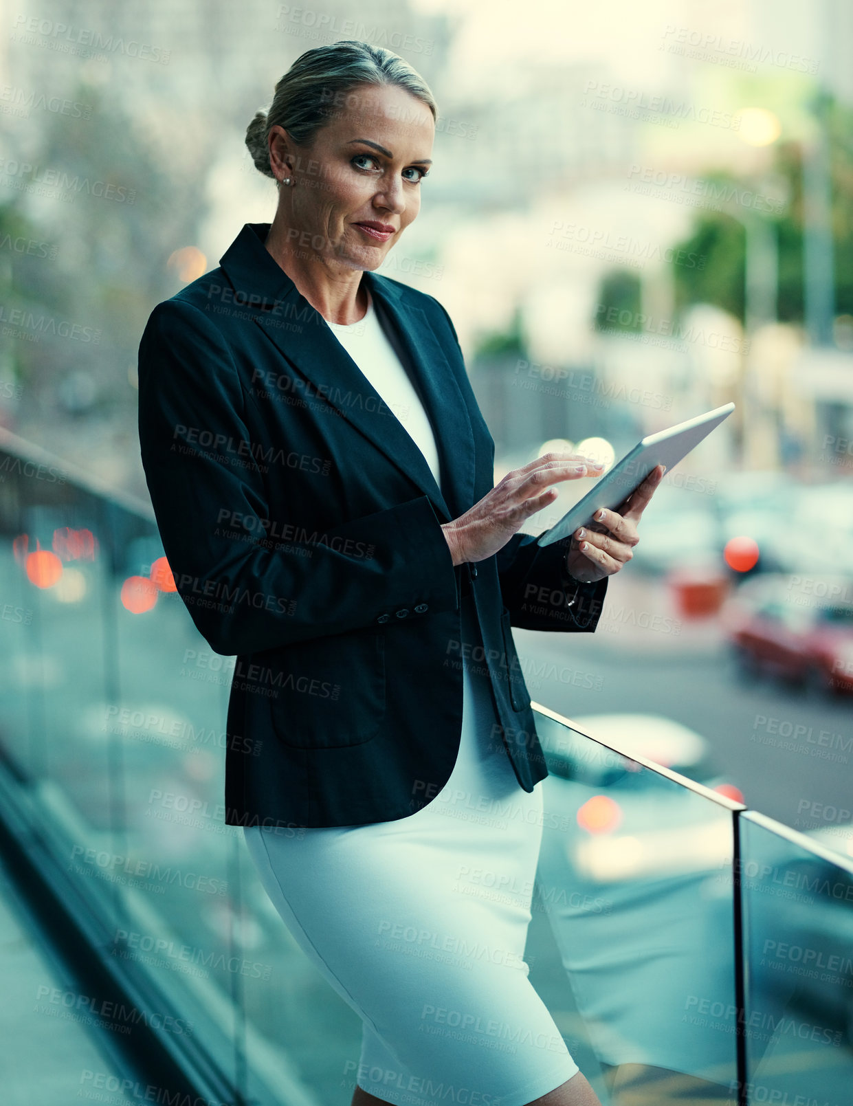 Buy stock photo Portrait of a mature businesswoman standing outside on the balcony of an office and using a digital tablet