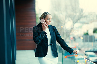 Buy stock photo Shot of a mature businesswoman standing outside on the balcony of an office and using a mobile phone