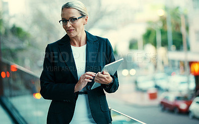 Buy stock photo Portrait of a mature businesswoman standing outside on the balcony of an office and holding a digital tablet