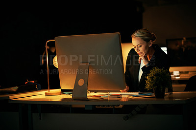 Buy stock photo Shot of a mature businesswoman working late at the office 