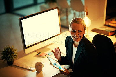 Buy stock photo Shot of a mature woman using her digital tablet while working late at the office