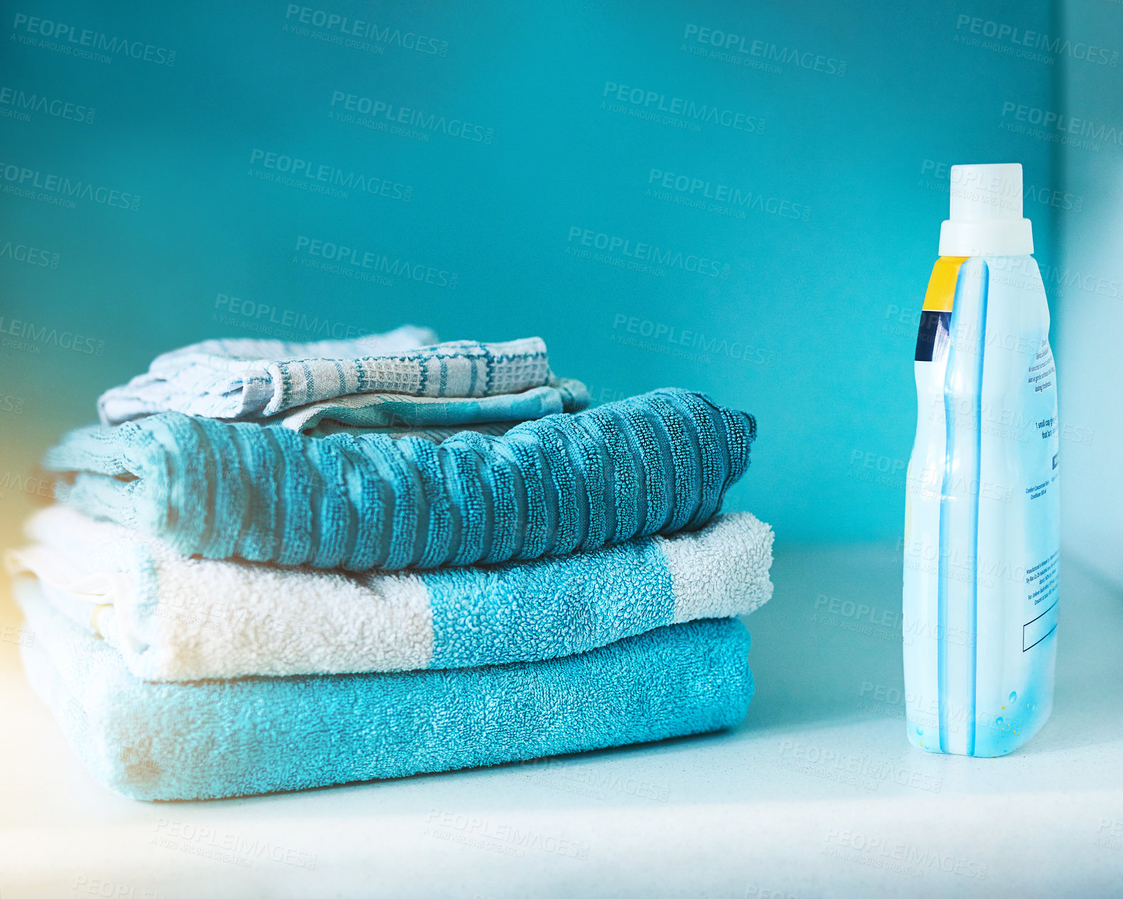 Buy stock photo Washing machine, towel and clean laundry in blue background with stack, product and mockup. Lens flare, fabric and electrical for energy, efficiency and furniture with stain removal for clothes