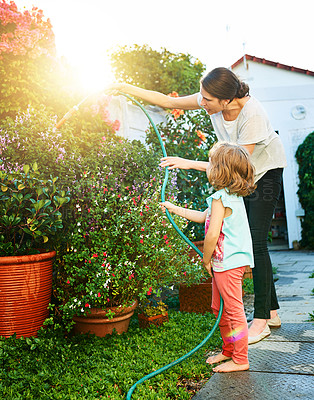 Buy stock photo Mom, girl and happy with watering garden for child development, growth and childhood memories. Parent, kid and enjoy with bonding, fun and educational for social learning, teaching or support at home