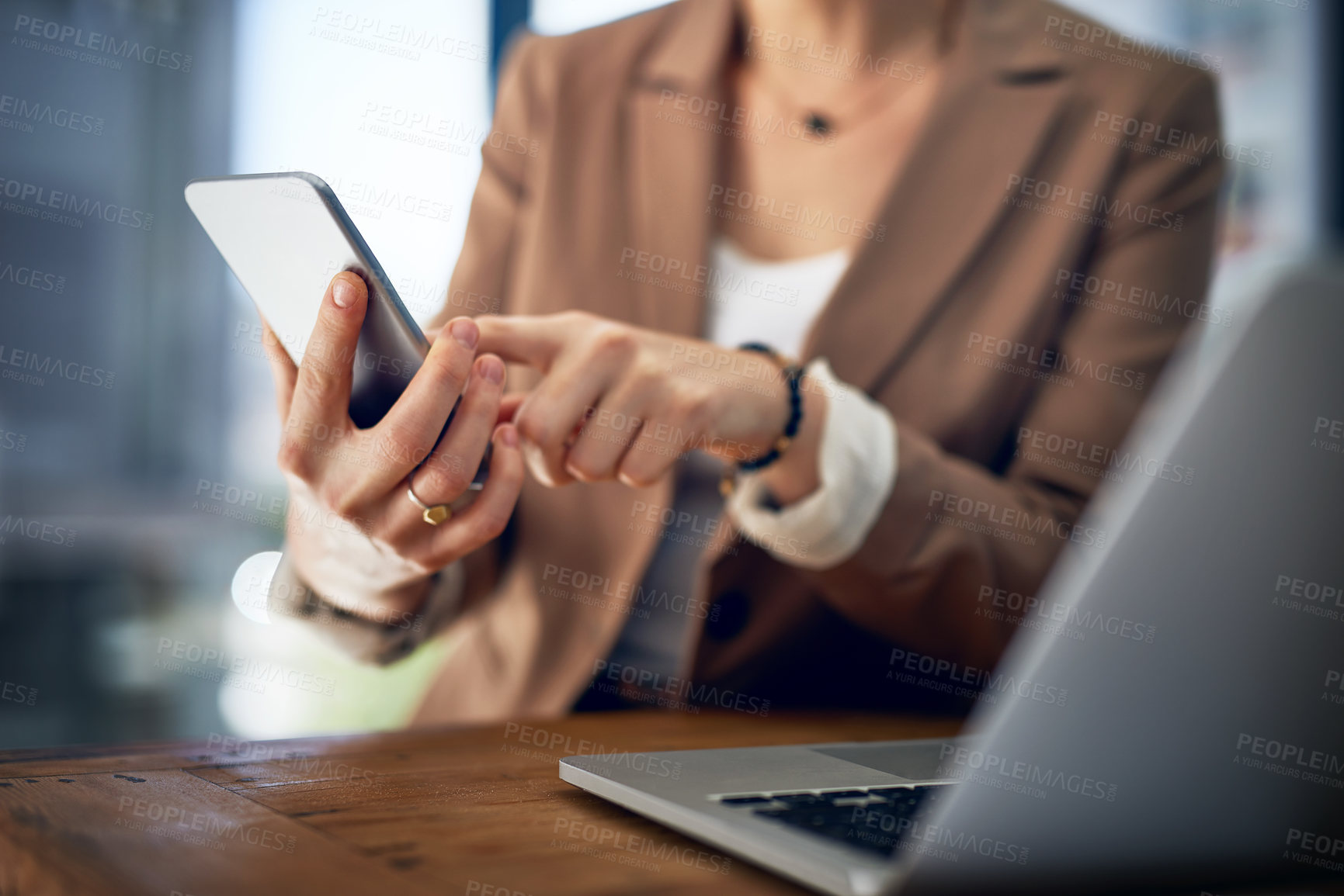 Buy stock photo Closeup shot of an unrecognizable businesswoman using her cellphone in an office