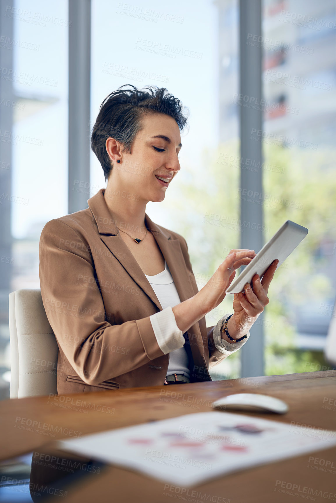 Buy stock photo Shot of a businesswoman working on a digital tablet in an office