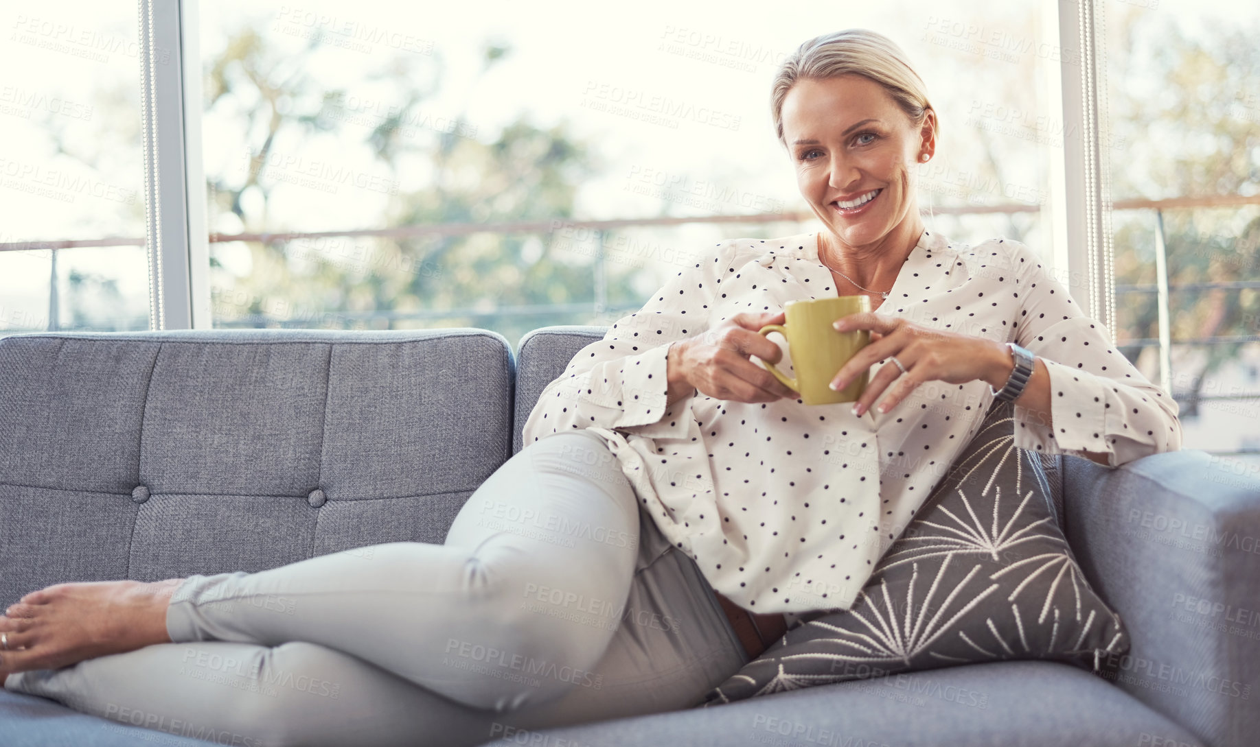 Buy stock photo Shot of a happy mature woman relaxing on the sofa at home