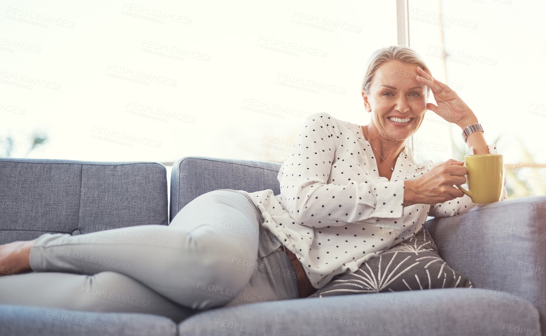 Buy stock photo Shot of a happy mature woman relaxing on the sofa at home