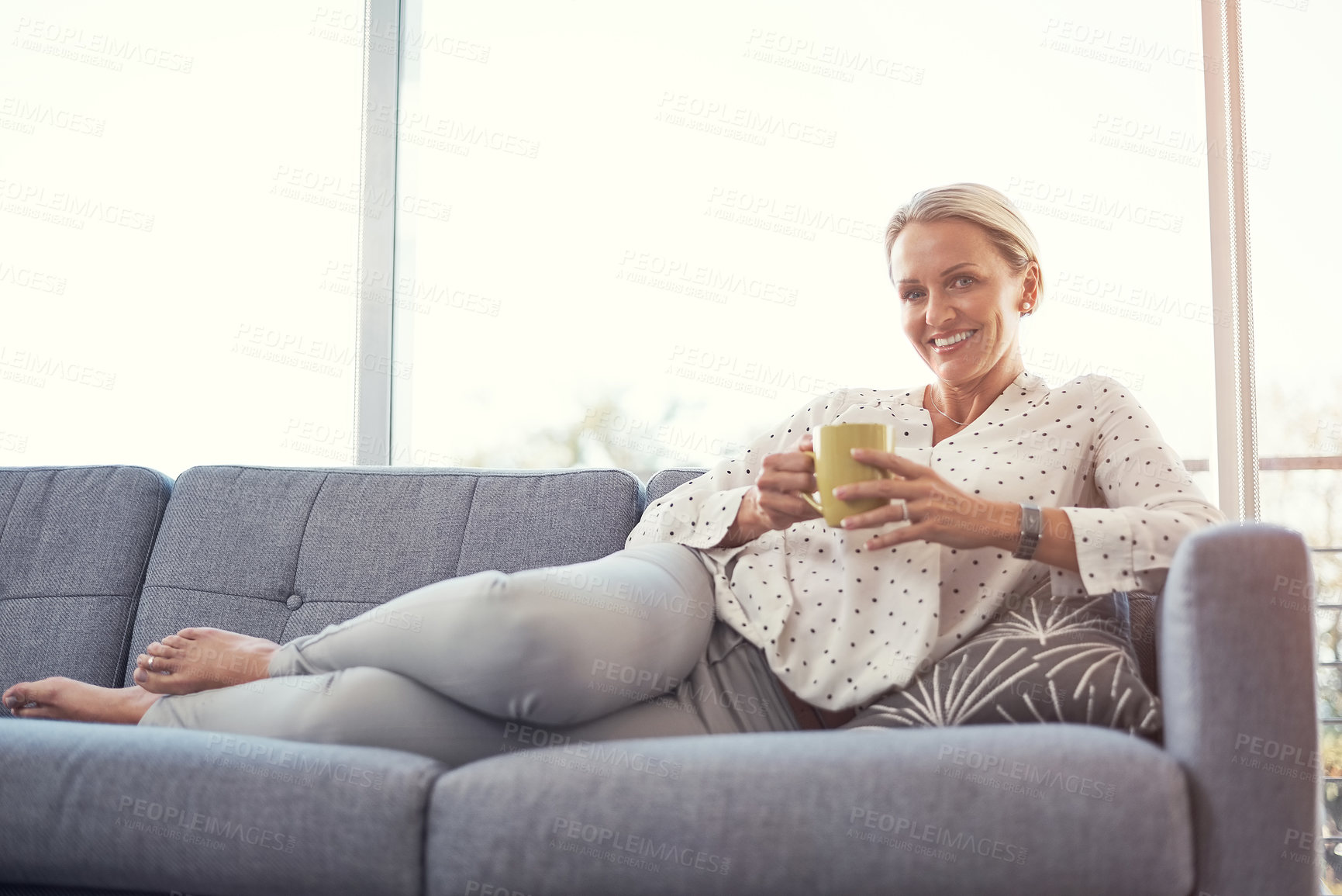 Buy stock photo Shot of a happy mature woman relaxing on the sofa at home