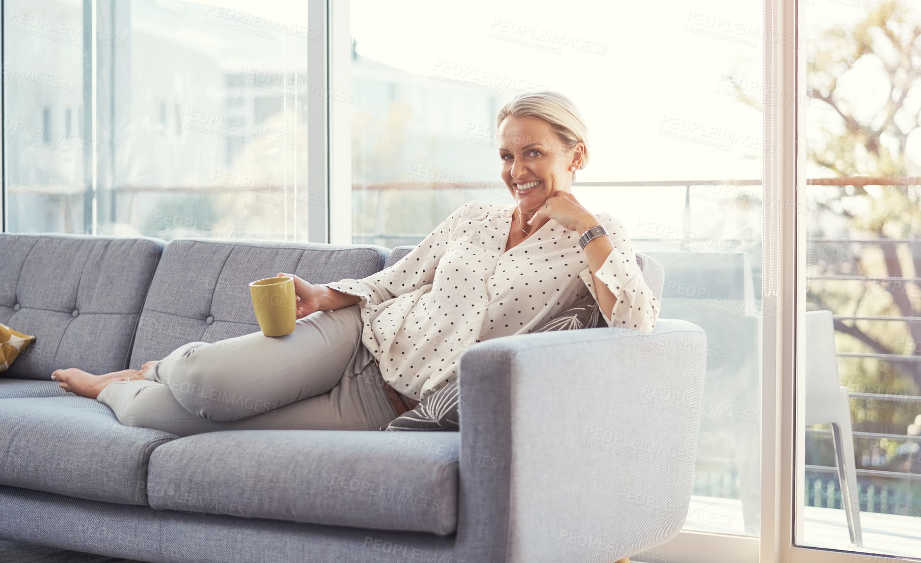 Buy stock photo Shot of a happy mature woman relaxing on the sofa at home