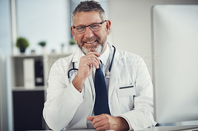 Buy stock photo Portrait of a mature doctor working at a desk in his office