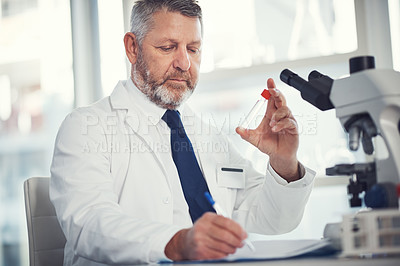 Buy stock photo Shot of a mature man conducting medical research in a laboratory