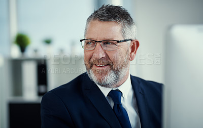 Buy stock photo Shot of a mature businessman working at his desk in a modern office