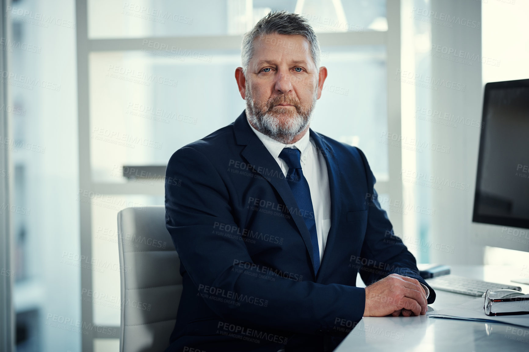 Buy stock photo Portrait of a mature businessman working at his desk in a modern office