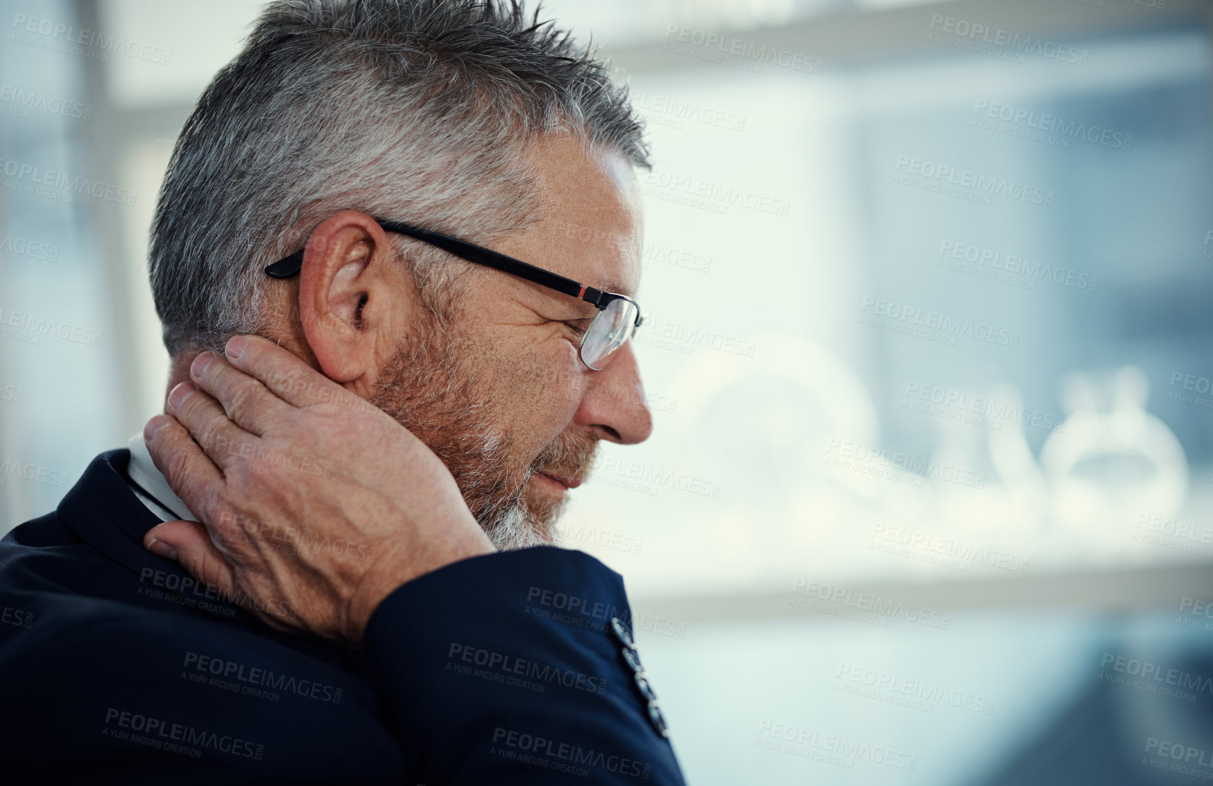 Buy stock photo Shot of a mature businessman experiencing neck ache at work in a modern office