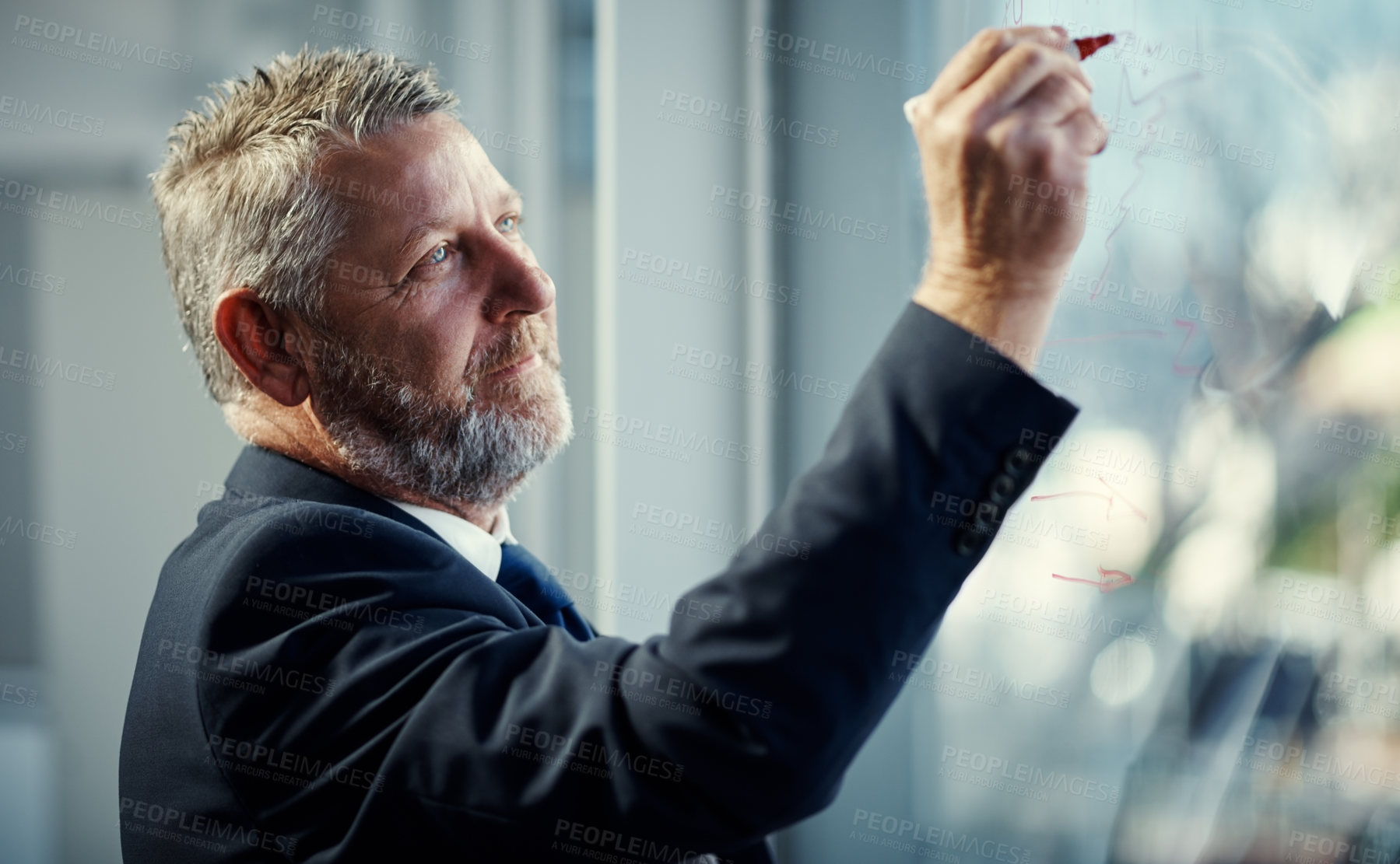 Buy stock photo Shot of a mature businessman having a brainstorming session against a glass screen in a modern office