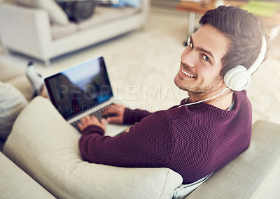 Buy stock photo Man, laptop and portrait with headphones on sofa in home with audio streaming, subscription service and online gaming. Person, music and smile on tech app for sound entertainment, radio and playlist