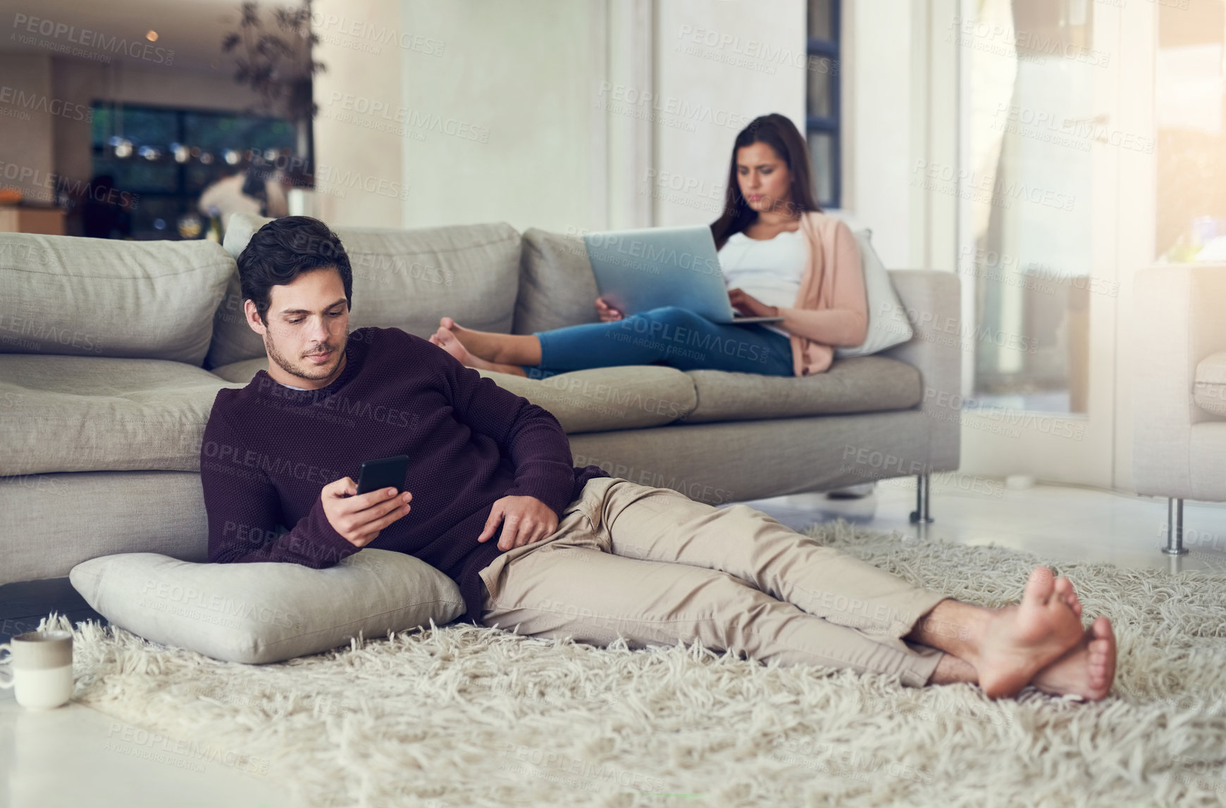 Buy stock photo Couple, reading and relax in living room with phone, laptop and social media notification on mobile app in home. Man, woman and tech on carpet for streaming, care or chat on vacation on sofa in house