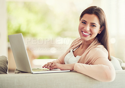 Buy stock photo Portrait of a cheerful young woman relaxing on the sofa and using her laptop at home