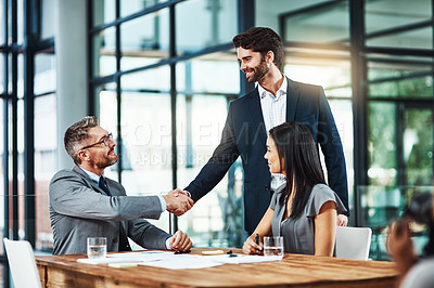 Buy stock photo Shot of businessmen shaking hands during a meeting in a modern office