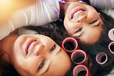 Buy stock photo High angle shot of a mother and her little girl wearing curlers while lying down
