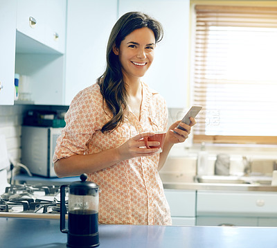 Buy stock photo Portrait of an attractive young woman having coffee and using a mobile phone at home