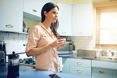 Buy stock photo Shot of an attractive young woman having a cup of coffee at home