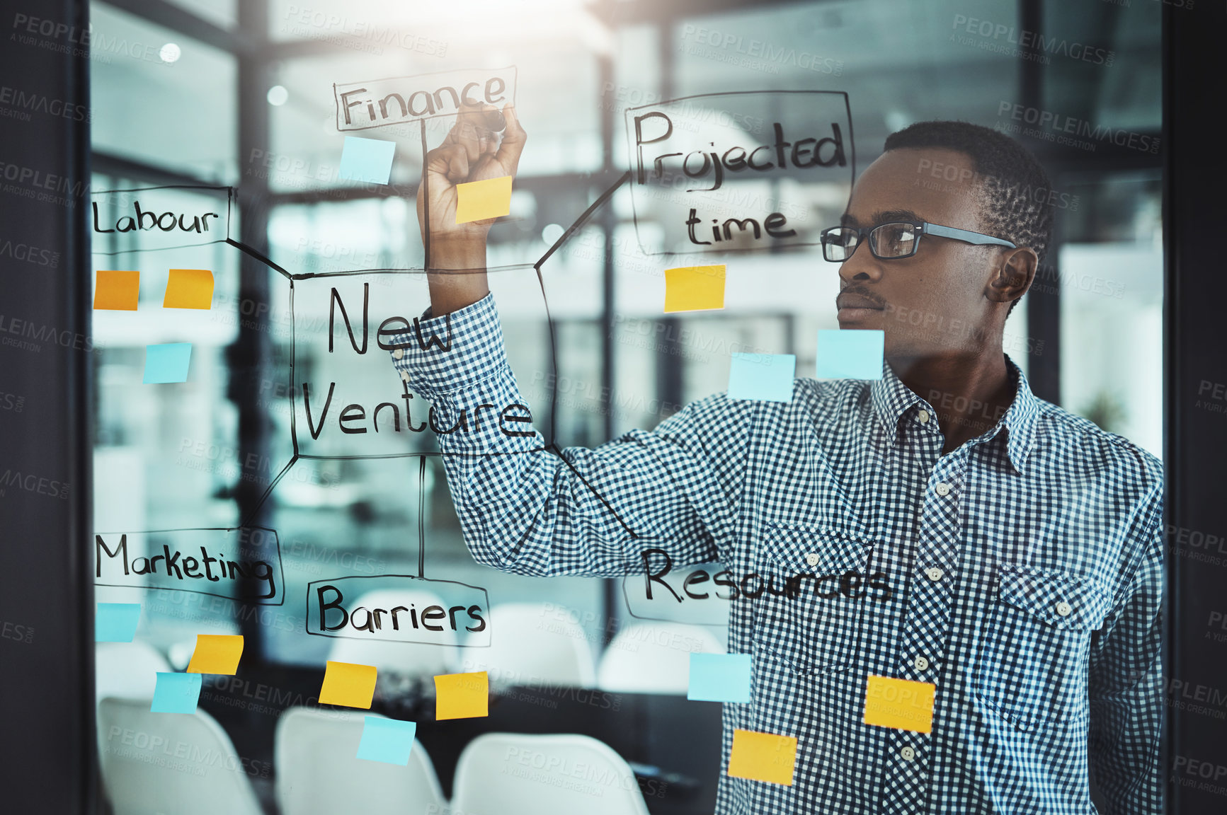 Buy stock photo Cropped shot of a handsome young businessman working on a glass wipe in the office