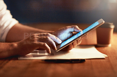 Buy stock photo Closeup of a persons hands holding and scrolling on a digital tablet planning late in the evening at night. Modern man working online with a touchscreen display device, at desk of workplace