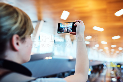 Buy stock photo Shot of an unrecognizable woman taking photos inside an airport 