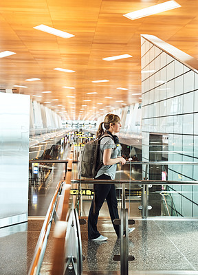 Buy stock photo Full length shot of an attractive young woman walking through an airport