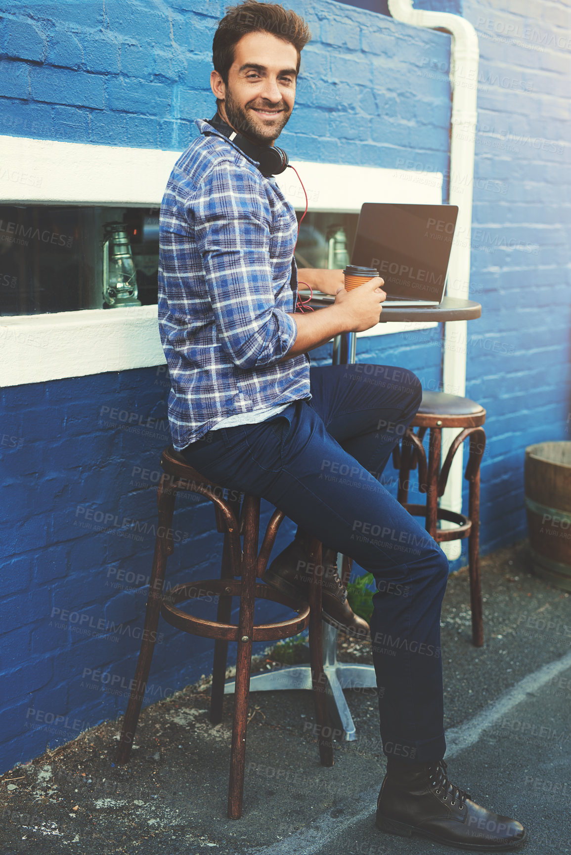 Buy stock photo Man, portrait and laptop at cafe as freelancer or content creator for travel blog, city or influencer. Male person, face and street coffee shop in Italy for writing article, brick wall or remote work