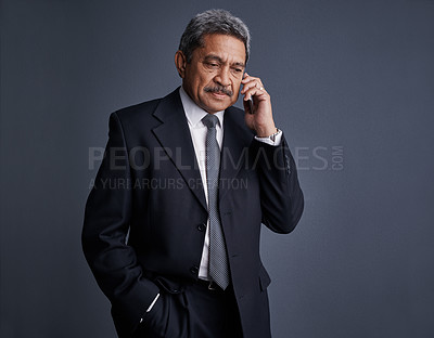Buy stock photo Studio shot of a mature businessman talking on his cellphone