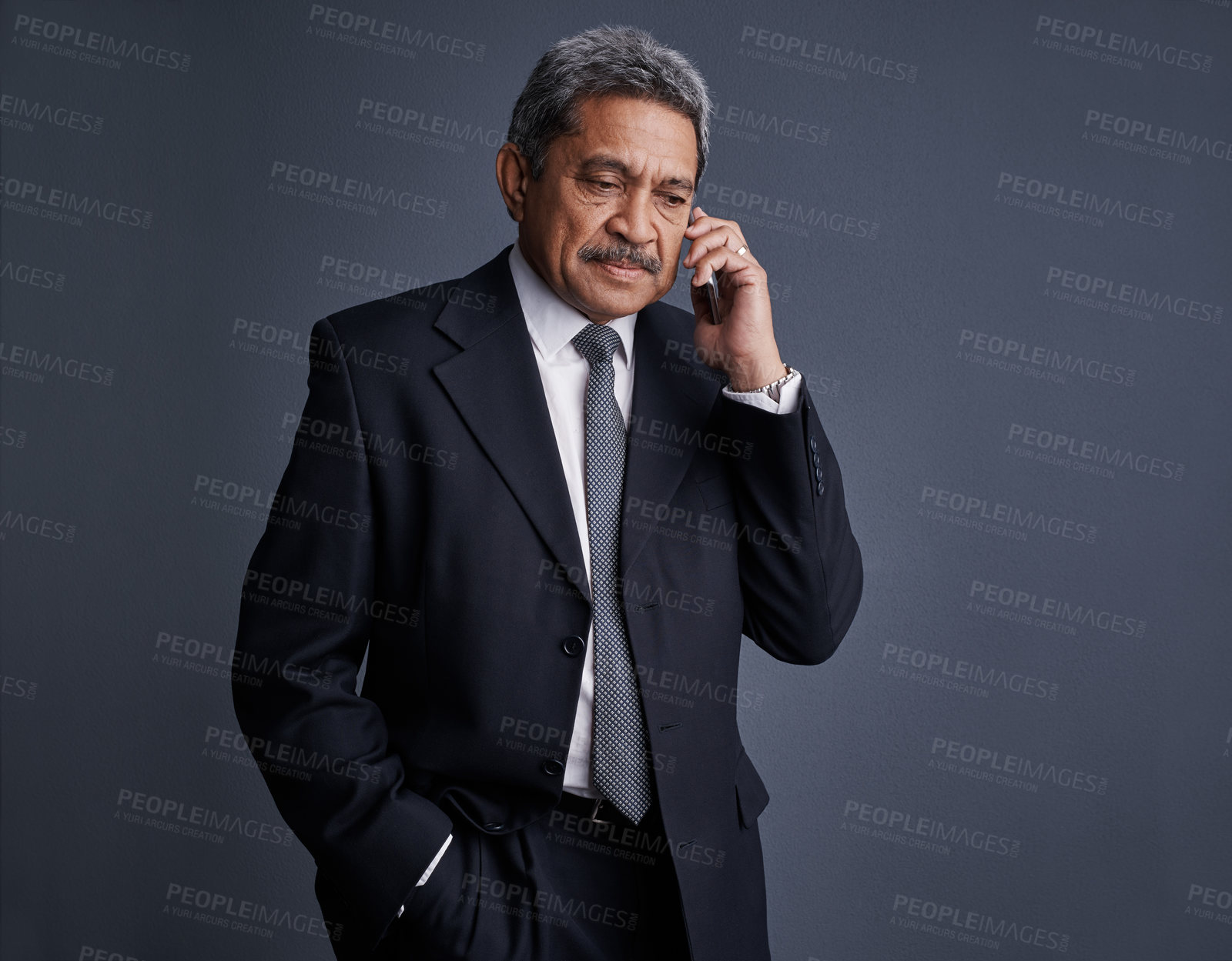 Buy stock photo Studio shot of a mature businessman talking on his cellphone