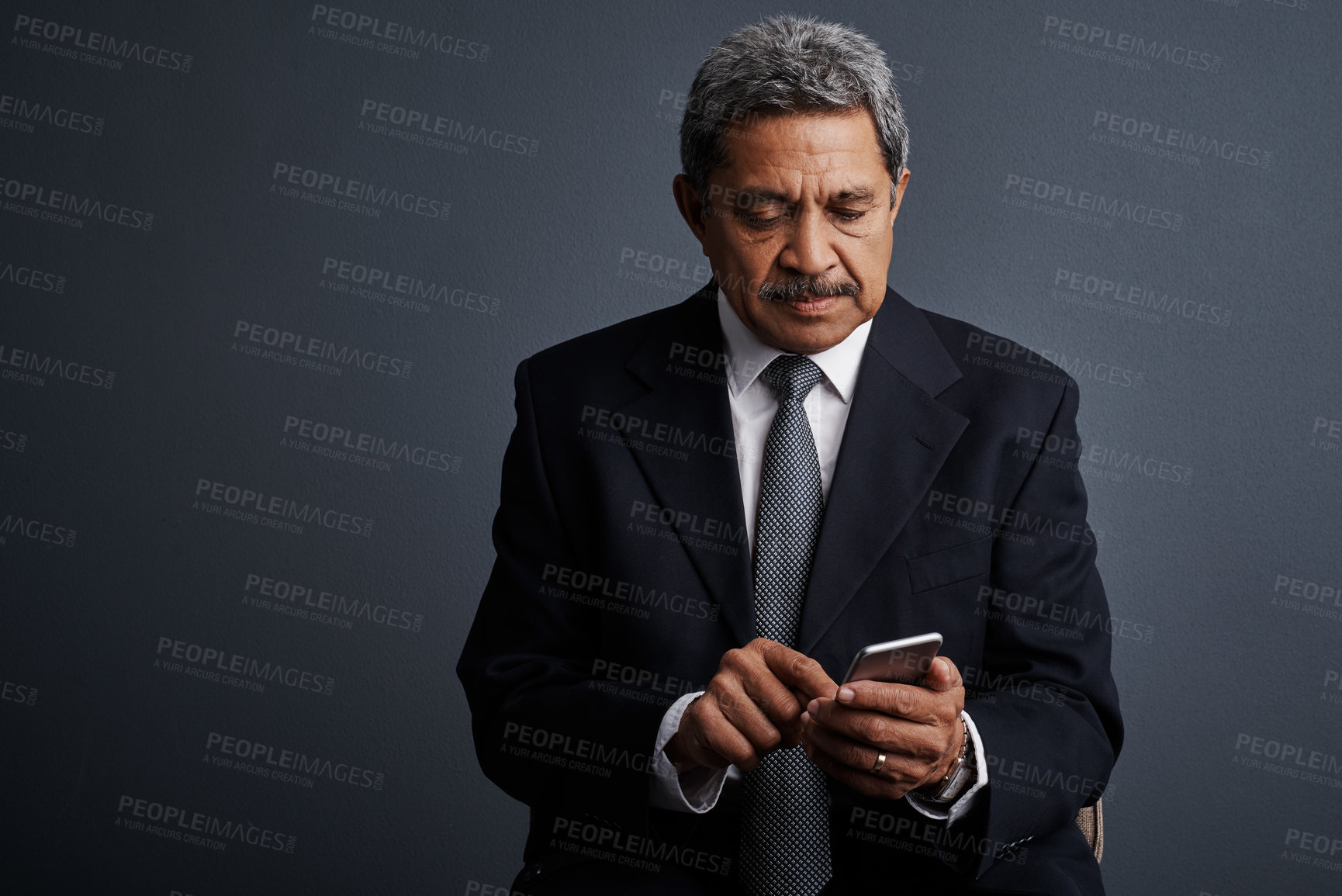 Buy stock photo Studio shot of a mature businessman using his cellphone