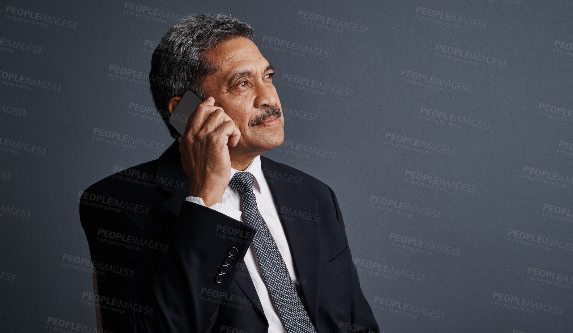 Buy stock photo Studio shot of a mature businessman talking on his cellphone