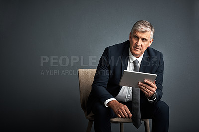 Buy stock photo Studio shot of a mature businessman using his digital tablet