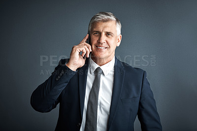 Buy stock photo Studio shot of a mature businessman talking on his cellphone