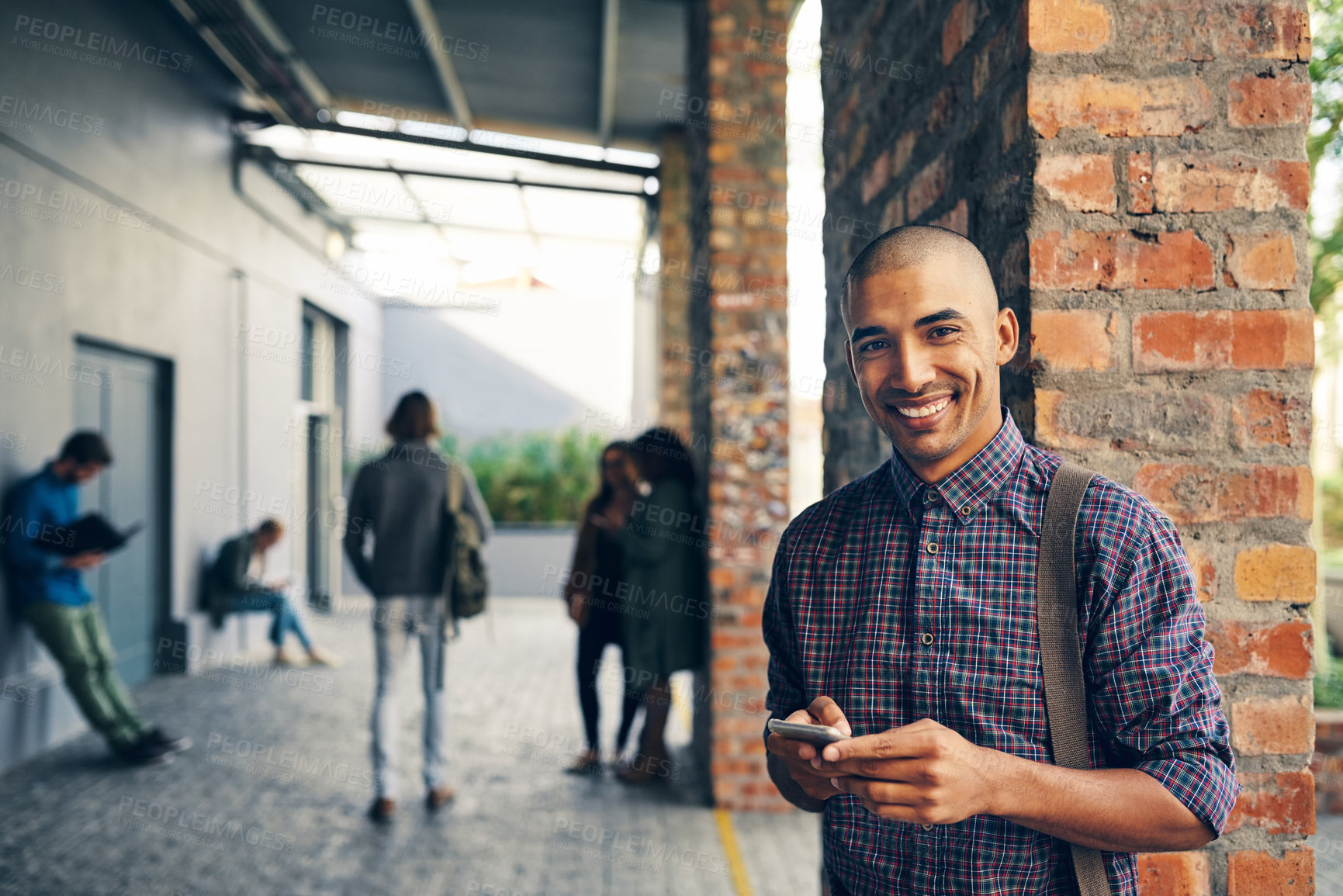 Buy stock photo Portrait of a young man using a mobile phone outdoors on campus