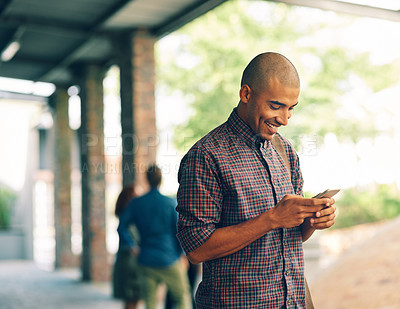 Buy stock photo Young man, student and texting with cellphone on campus, university and happy with social media app. Guy, smartphone and happiness outdoor for connectivity, blog and email communication on internet