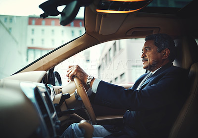 Buy stock photo Shot of a mature businessman driving a stylish car